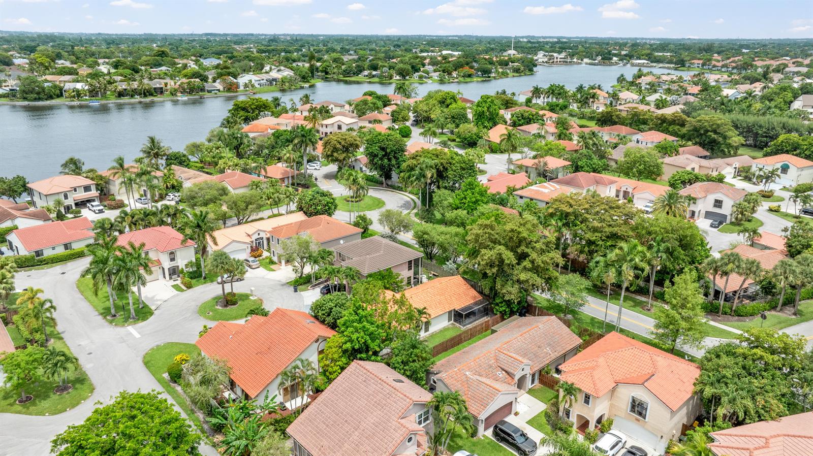 An aerial view shows a residential neighborhood with tile-roofed houses and a large lake — 1763 Harborside Circle, Wellington FL 33414, WELLINGTON, FL