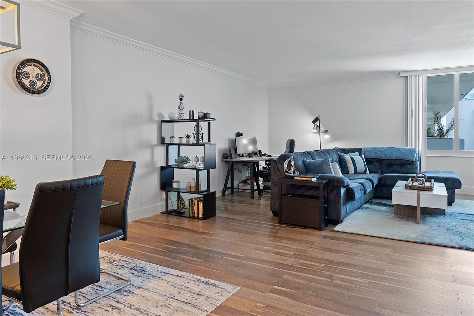 A living room features wood flooring, a blue sectional sofa, and a dining area — 1200 West Ave, Miami Beach FL 33139, MIAMI BEACH, FL