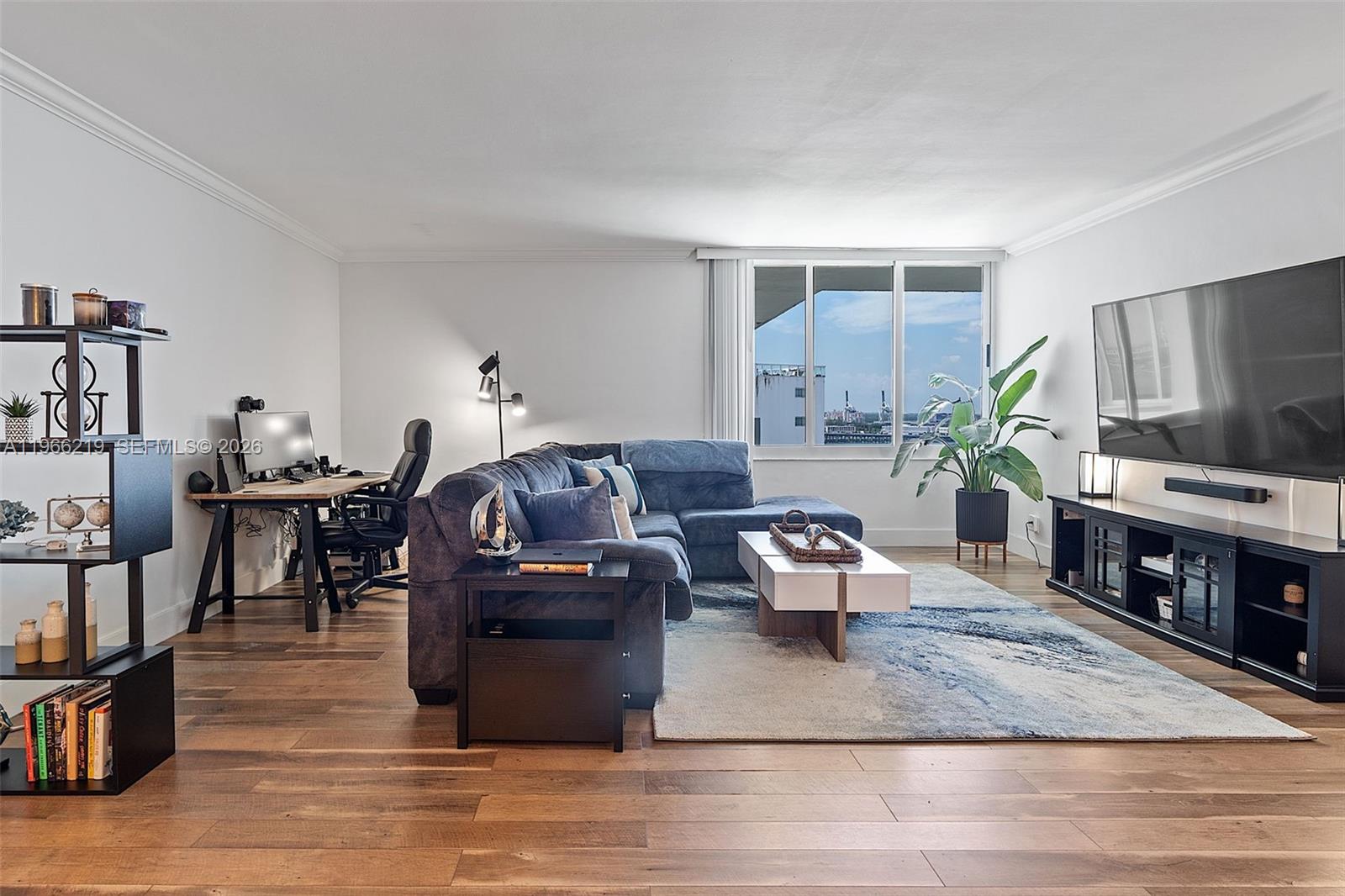 A living room features a sectional sofa, a desk area, and a large television — 1200 West Ave, Miami Beach FL 33139, MIAMI BEACH, FL