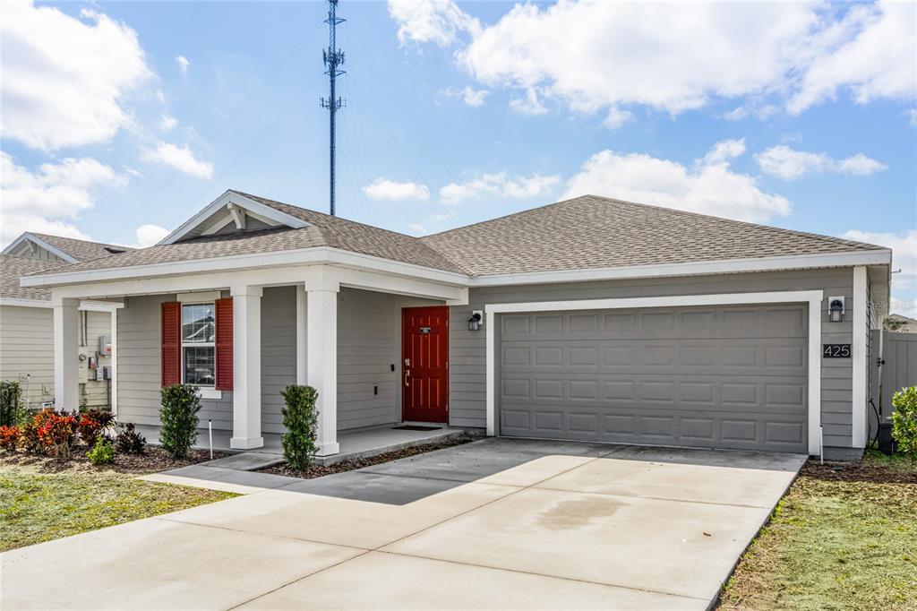 A single-story house with gray siding, a red front door, and a two-car garage — 425 N ANDREA CIRCLE, HAINES CITY, FL
