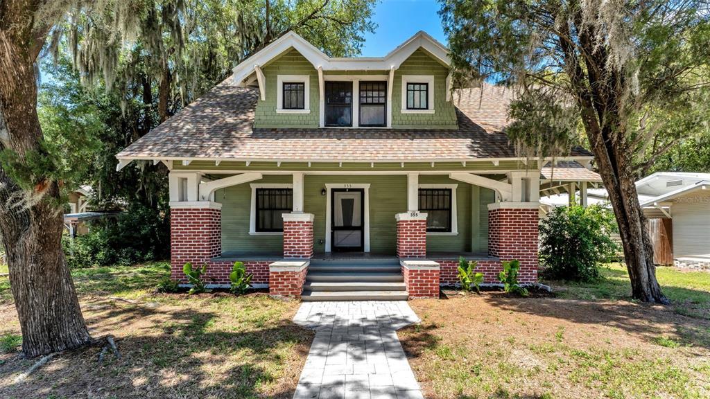 A green bungalow with a brick porch base and a front-facing dormer window — 355 S BROADWAY AVENUE, BARTOW, FL