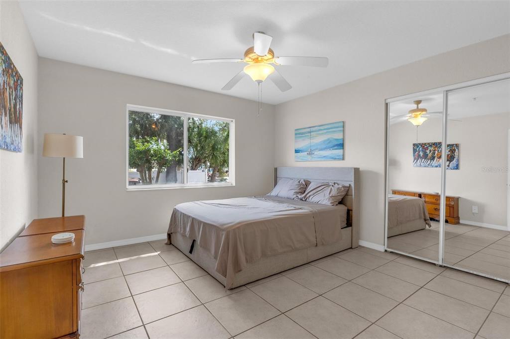 A bedroom features a bed, a dresser, a ceiling fan, and mirrored closet doors — 545 WAYNE AVENUE, NEW SMYRNA BEACH, FL