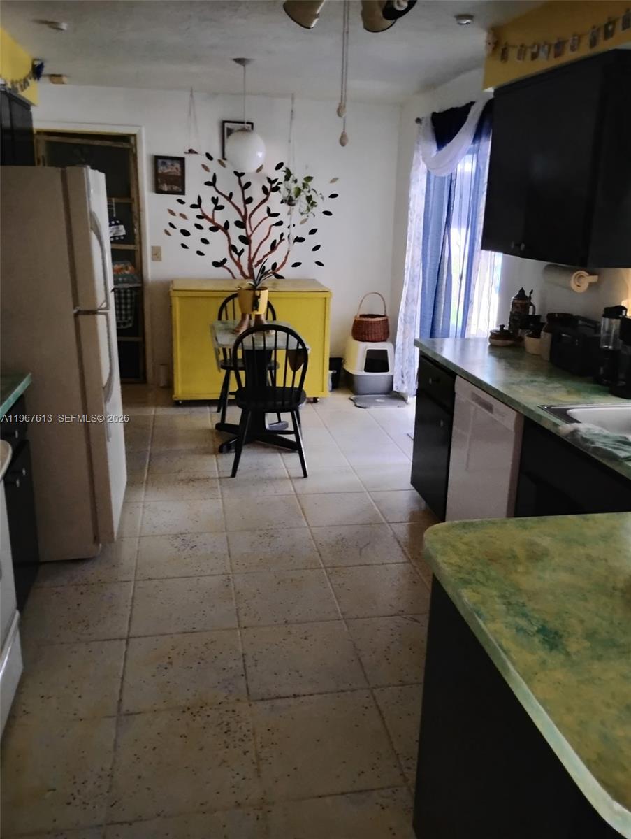 A kitchen features tile flooring, dark cabinets, a yellow storage chest, and a dining table — 477 W BUTTONBUSH Dr, Citrus Springs FL 34465, CITRUS SPRINGS, FL