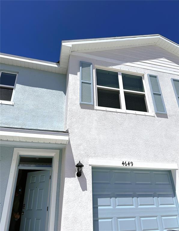 The exterior of a two-story house features a light blue door and a garage — 4649 PLEASANT AVENUE, PALM HARBOR, FL