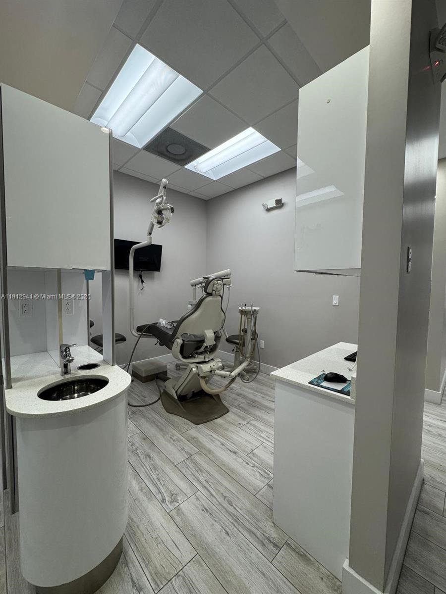 A dental exam room features a patient chair, a sink, and white cabinetry — 9440 W Commercial Blvd, Sunrise FL 33351, SUNRISE, FL