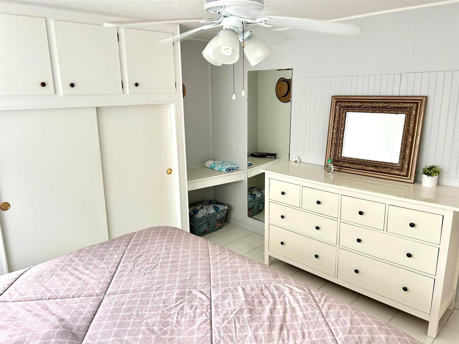 A bedroom features a white dresser, a gold-framed mirror, and a light-colored quilt — 3240 State Street, Hollywood FL 33021, HOLLYWOOD, FL