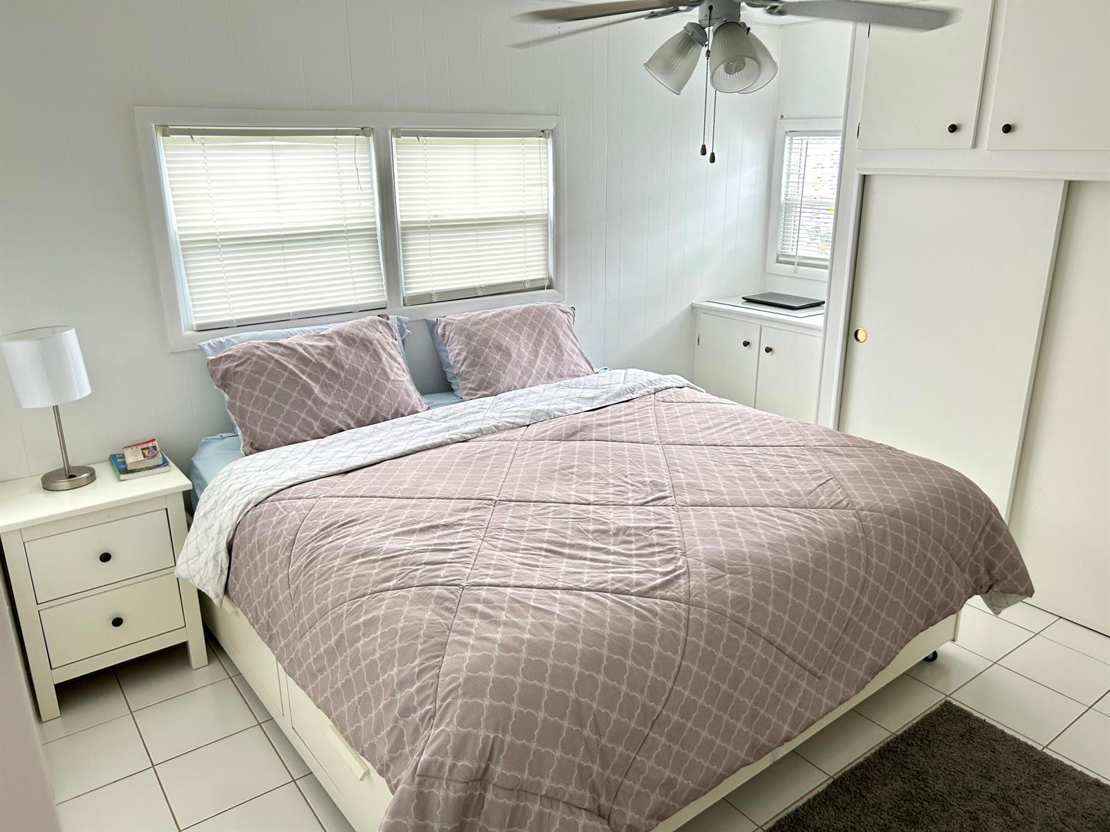 A bedroom features a bed with a patterned comforter, white walls, and tiled flooring — 3240 State Street, Hollywood FL 33021, HOLLYWOOD, FL