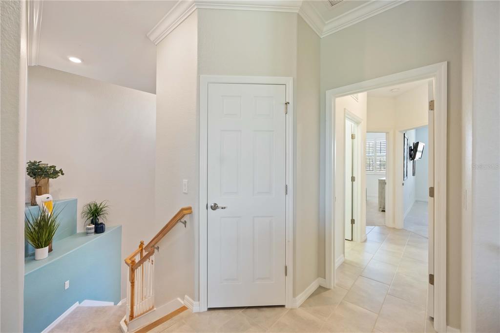 An interior view shows a staircase with a blue ledge, a white door, and a hallway — 10817 TARFLOWER DRIVE UNIT 201, VENICE, FL