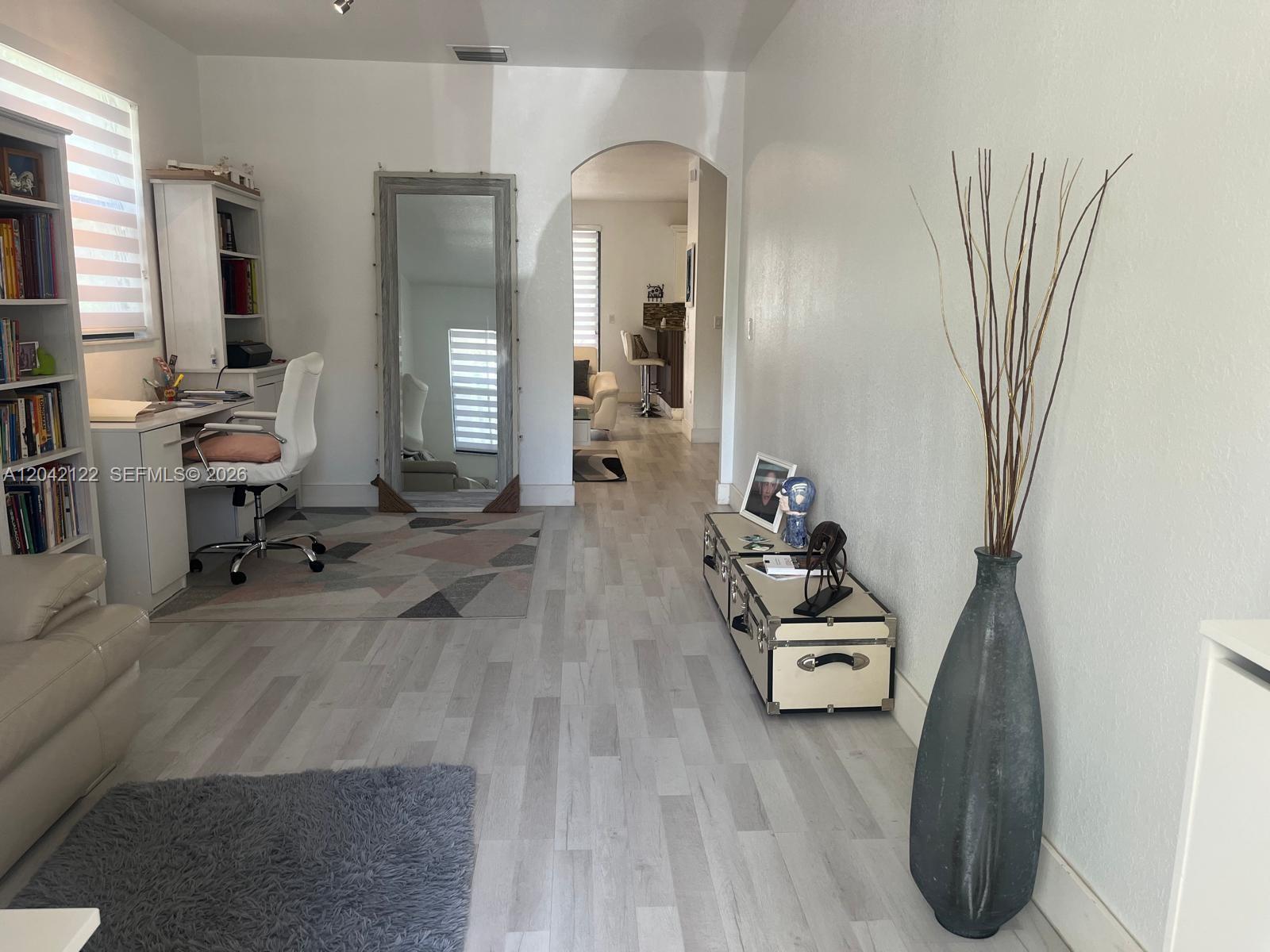 A bright room features a desk, a large floor mirror, and a decorative floor vase — 8985 NW 98th Ave, Doral FL 33178, DORAL, FL