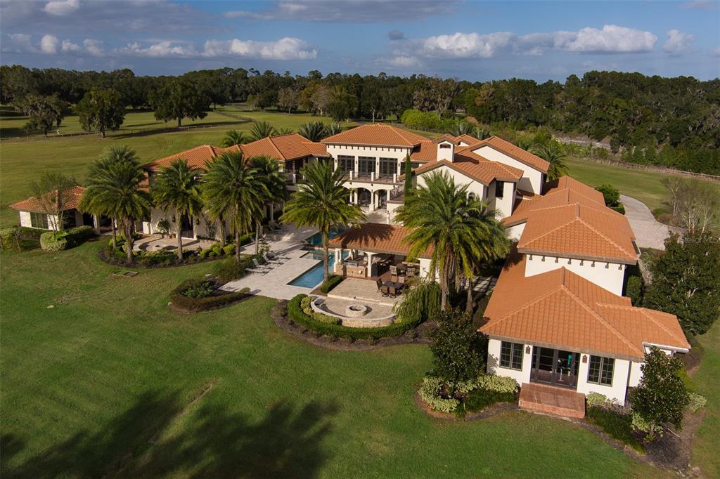 An aerial view of a large Mediterranean-style house with a tile roof and swimming pool — 9020 SW 9TH STREET ROAD, OCALA, FL