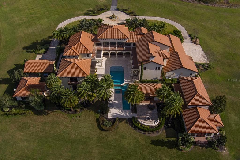 An aerial view of a large Mediterranean-style estate with a central pool and tiled roof — 9020 SW 9TH STREET ROAD, OCALA, FL