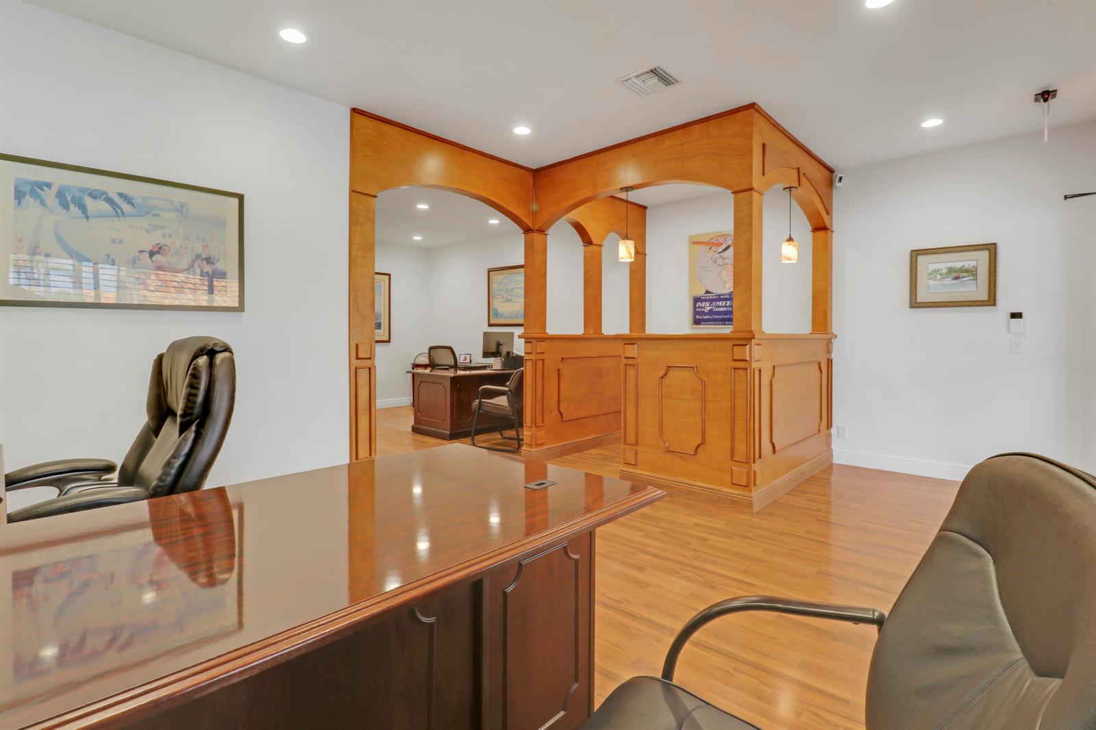 An office space features wood flooring, a wooden reception partition, and two dark leather chairs — 725 N Hwy A1a # C110, Jupiter FL 33477, JUPITER, FL