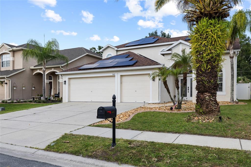 A two-story suburban house with a two-car garage and solar panels on the roof — 3602 MORGANS BLUFF COURT, LAND O LAKES, FL