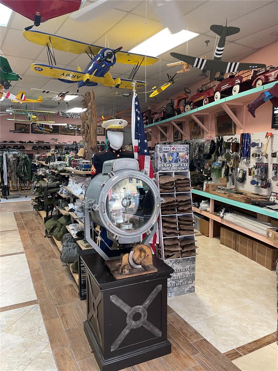 A retail store interior displays military memorabilia, model airplanes, and supplies on shelves and racks — 755 NW Federal Hwy, Stuart FL 34997, STUART, FL