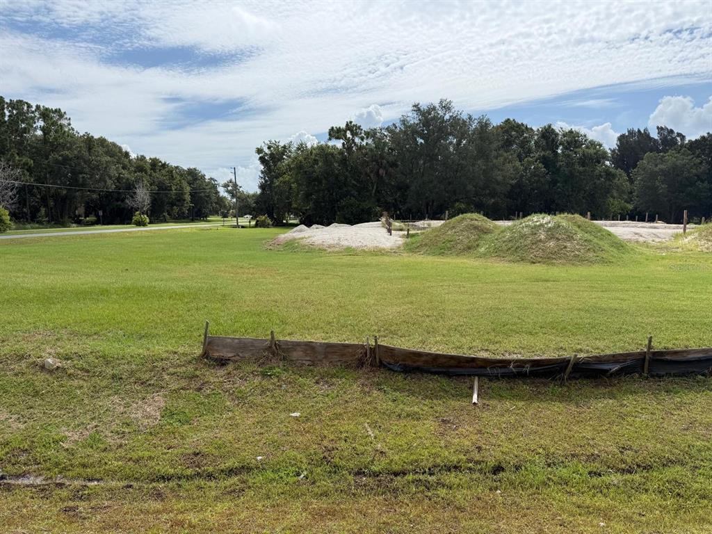 A grassy vacant lot features piles of dirt and a silt fence in the foreground — 2965 LUCKY CIRCLE, KISSIMMEE, FL