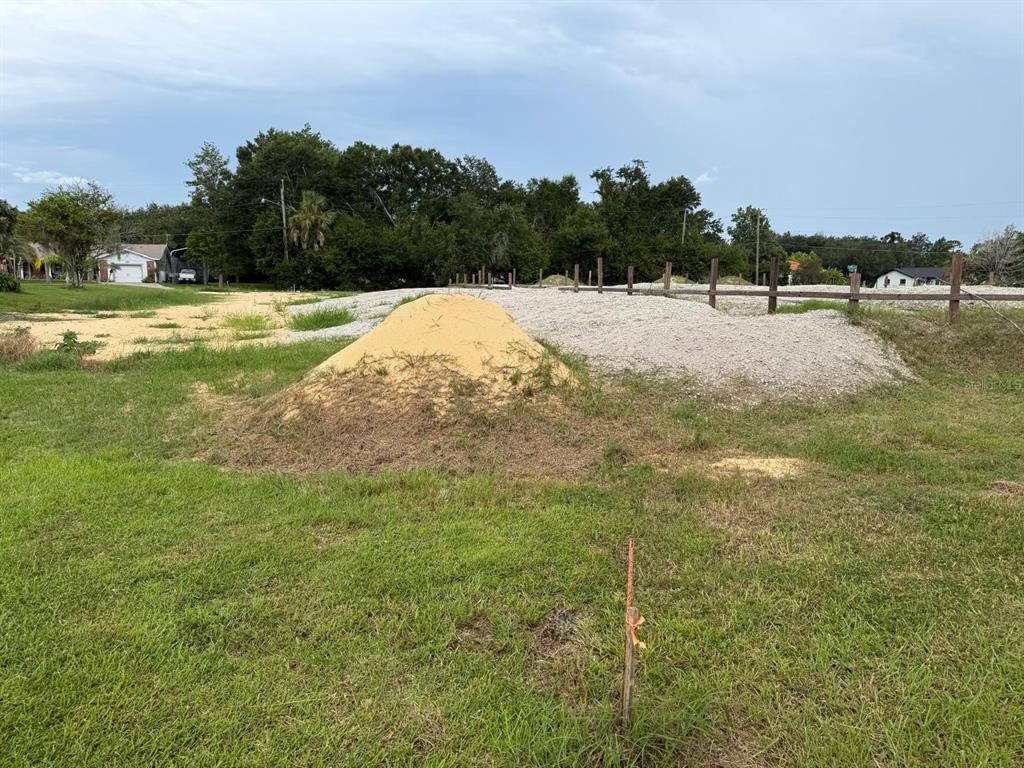 A vacant lot features a pile of sand and gravel behind a wooden fence — 2965 LUCKY CIRCLE, KISSIMMEE, FL