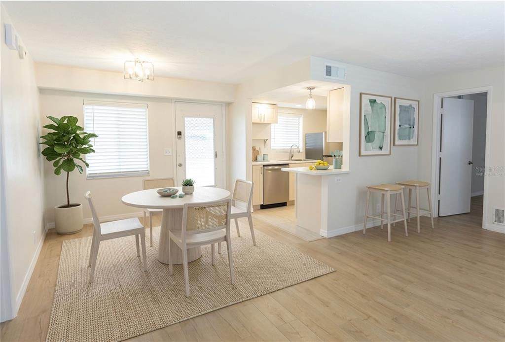 A dining area with a round table and chairs sits adjacent to a kitchen — 3751 S SCHOOL AVENUE UNIT 26, SARASOTA, FL