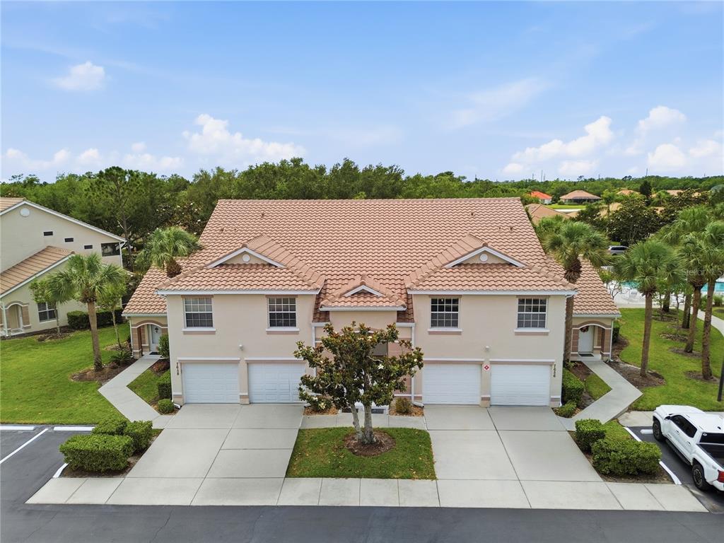 An aerial view shows a residential neighborhood with townhomes, a swimming pool, and a nearby highway — 7660 SWEETBAY CIRCLE, BRADENTON, FL