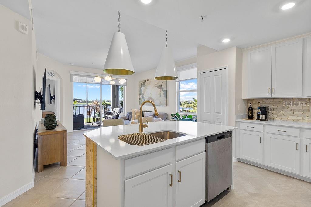 A kitchen with a white island, stainless steel dishwasher, and a view of a balcony — 5583 DOUBLE EAGLE CIRCLE UNIT 4128, AVE MARIA, FL