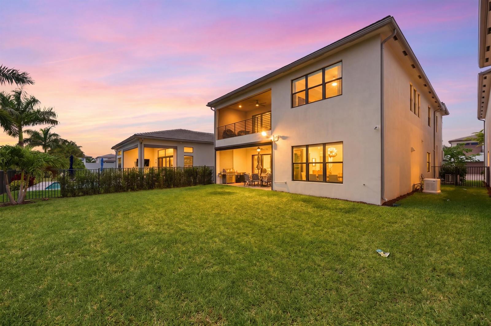 A two-story house with a backyard lawn, covered patio, and balcony at sunset — 8568 Crystal Downs Avenue, Boca Raton FL 33434, BOCA RATON, FL