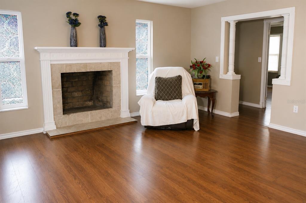A living room features a fireplace, a white armchair, and hardwood flooring — 655 PINECREST DRIVE, BARTOW, FL
