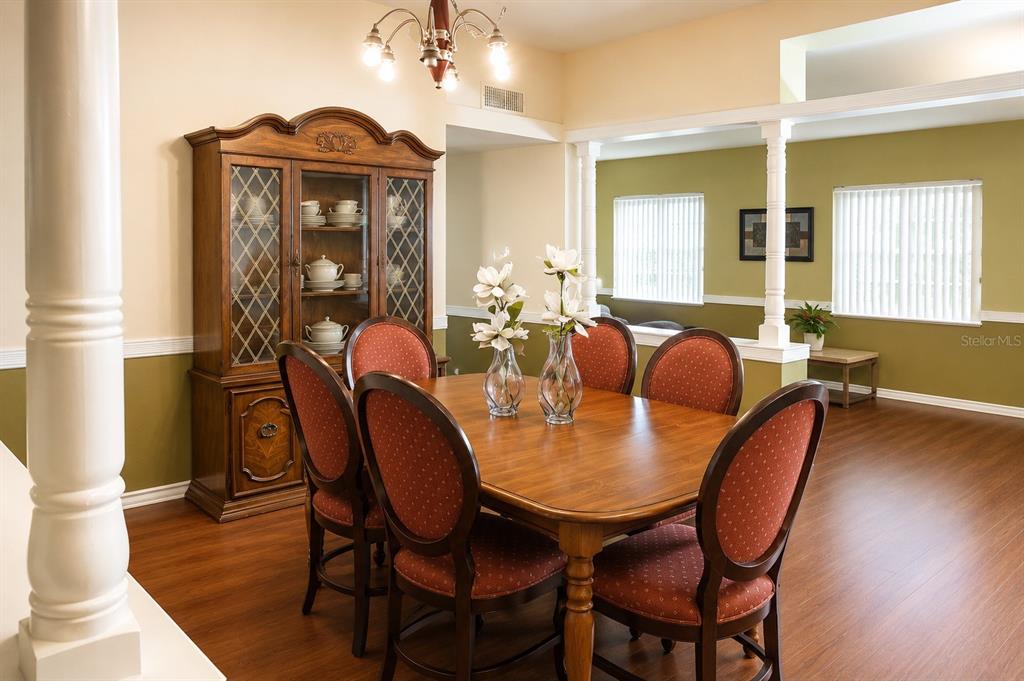 A dining room features a wooden table with six chairs, a hutch, and white columns — 655 PINECREST DRIVE, BARTOW, FL