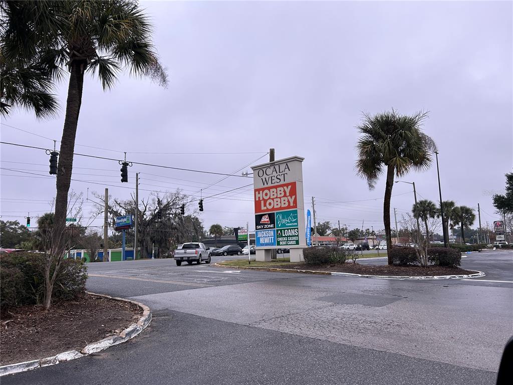 A street-level view shows a shopping center sign for Ocala West with palm trees nearby — 2400 SW COLLEGE ROAD UNIT 104, OCALA, FL