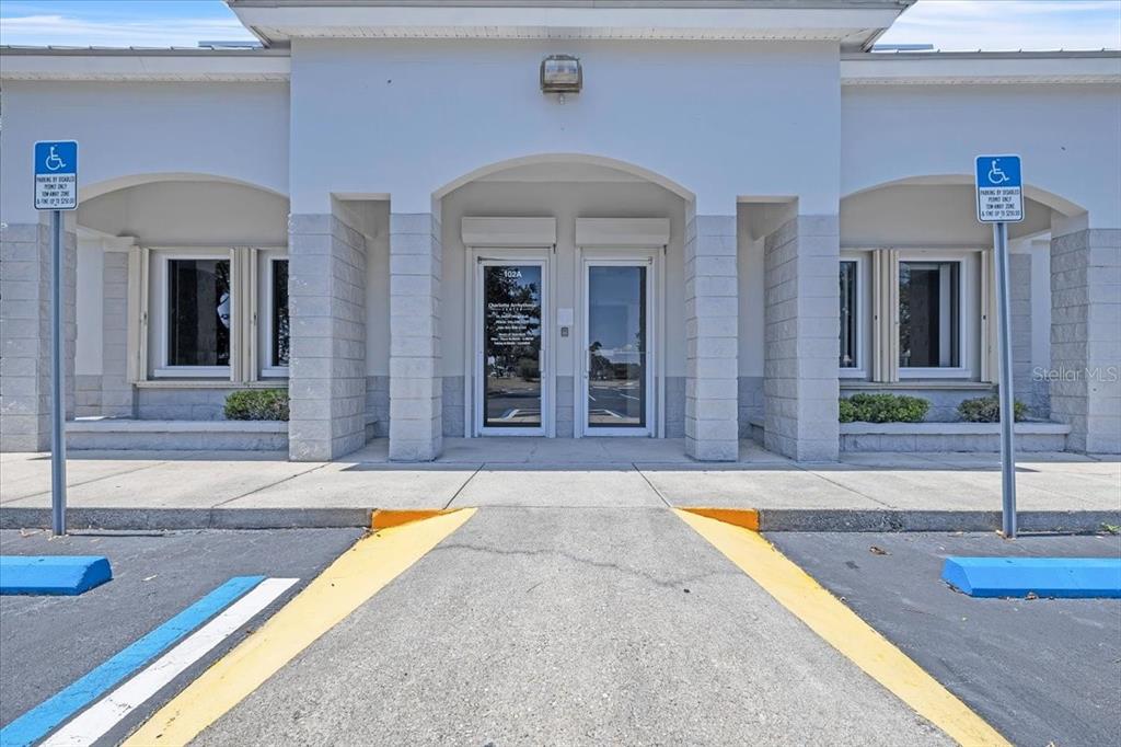The exterior of a commercial building features a central entrance with two glass doors — 3300 TAMIAMI TRAIL UNIT 102 B, PORT CHARLOTTE, FL
