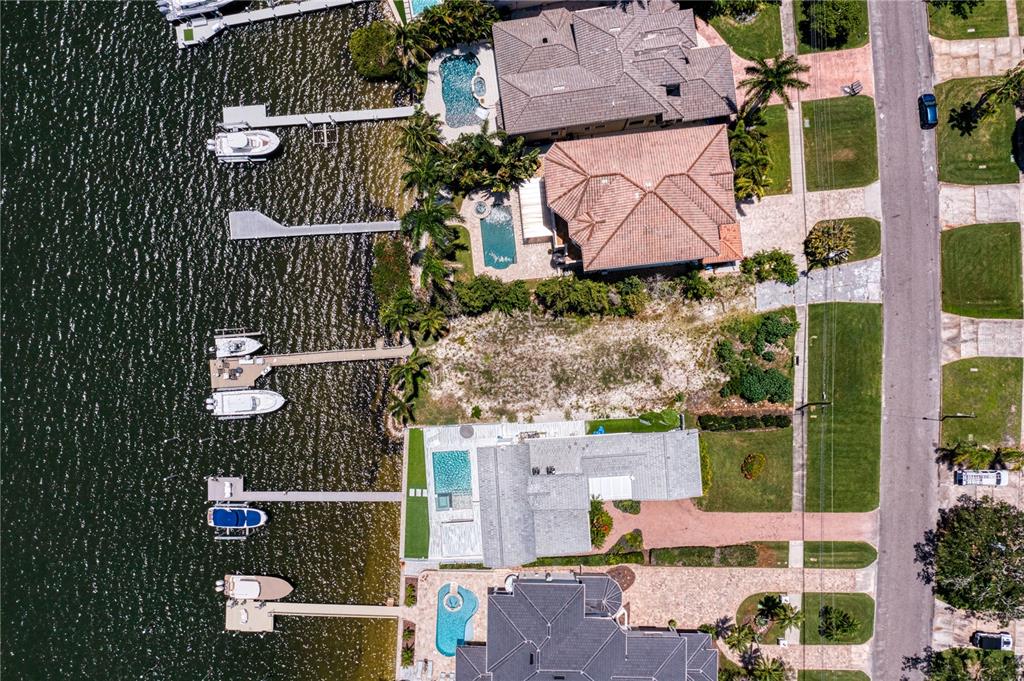 Aerial view of waterfront houses with private docks, swimming pools, and landscaped yards — 6527 BAYOU GRANDE BLVD NE, ST PETERSBURG, FL
