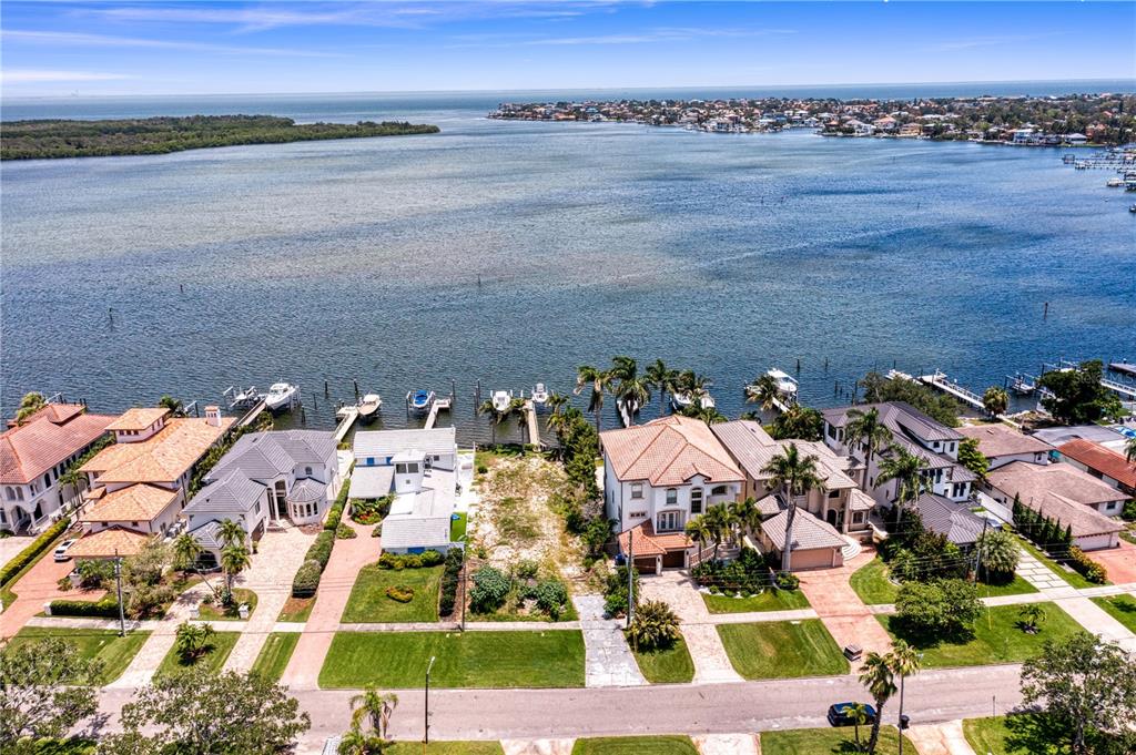 An aerial view shows waterfront homes with private docks along a bay — 6527 BAYOU GRANDE BLVD NE, ST PETERSBURG, FL
