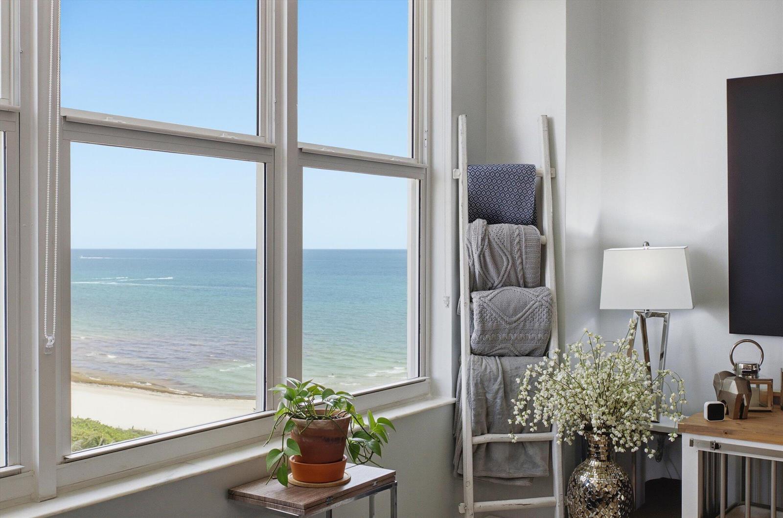 A room features a large window overlooking the ocean, a blanket ladder, and a plant — 4747 Collins Avenue # 1109, Miami Beach FL 33140, MIAMI BEACH, FL