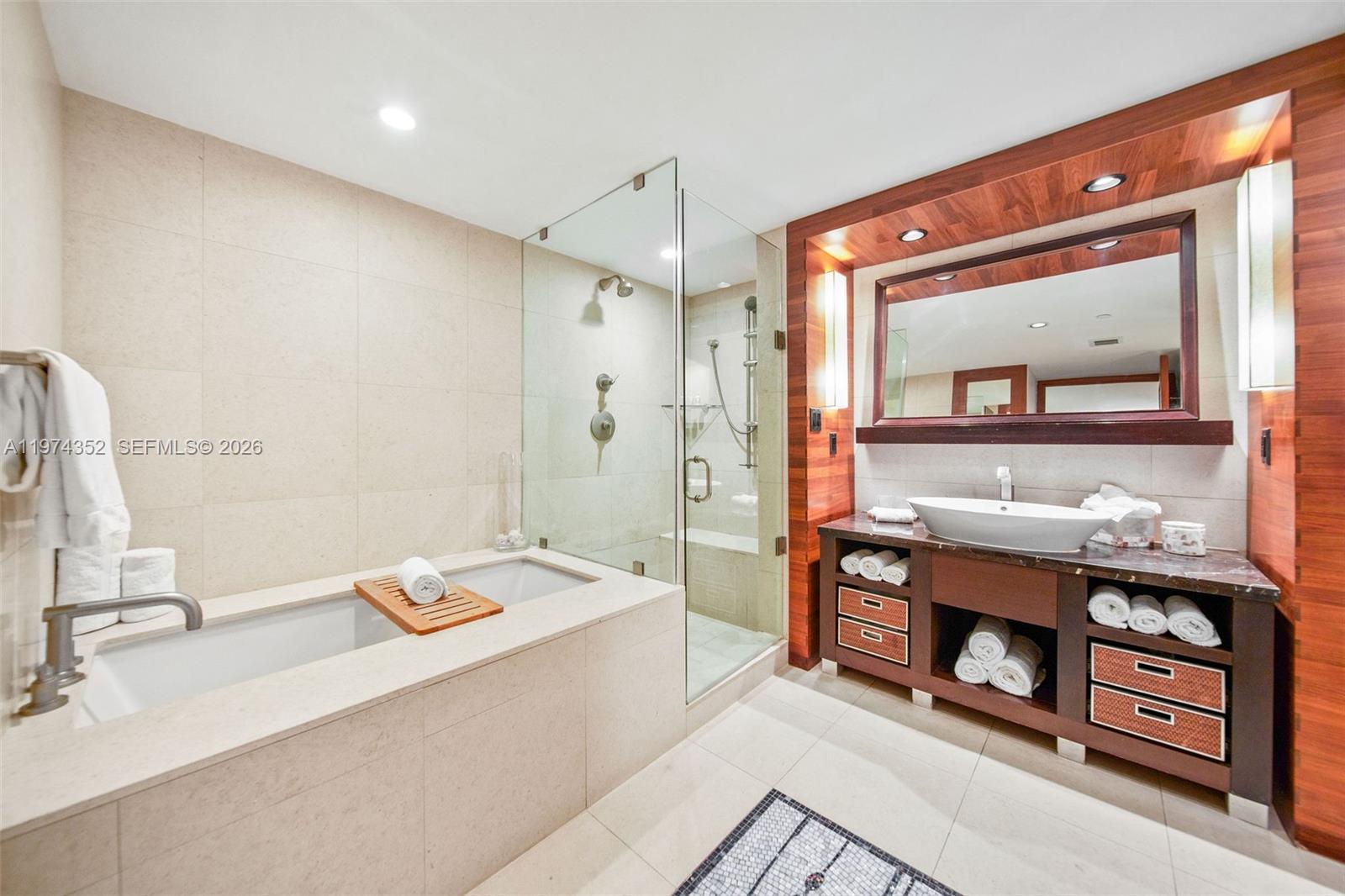 A modern bathroom features a soaking tub, glass-enclosed shower, and a dark wood vanity — 6801 Collins Ave # 604, Miami Beach FL 33141, MIAMI BEACH, FL