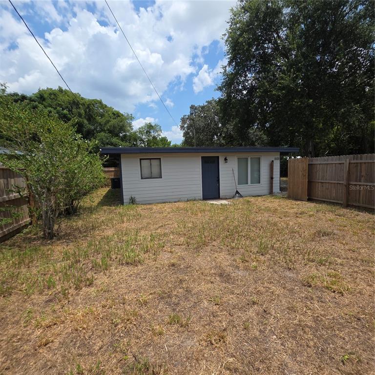 A small, single-story house with light-colored siding stands in a dry, grassy yard — 5101 ORANGE AVENUE N UNIT B, WINTER PARK, FL