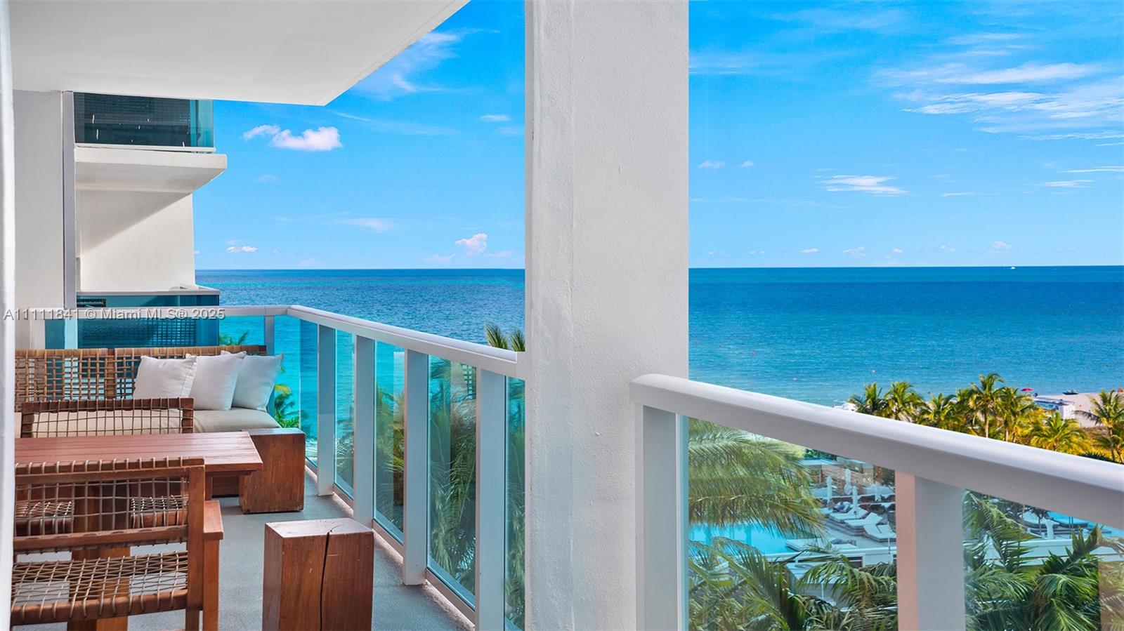 A balcony with outdoor furniture overlooks the ocean and a swimming pool below — 102 24th St # 904, Miami Beach FL 33139, MIAMI BEACH, FL