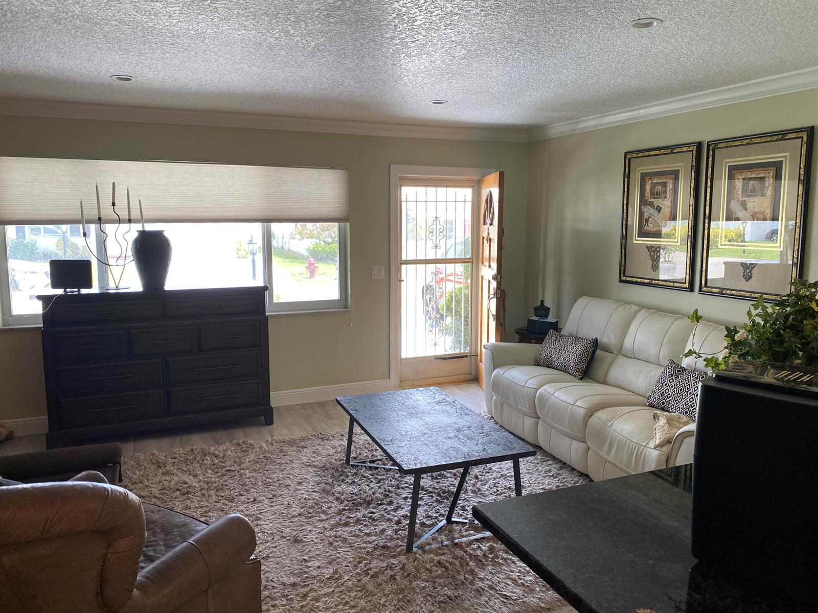 A living room features a white sofa, a dark dresser, and a coffee table — 1101 Leisure Lane, Boynton Beach FL 33426, BOYNTON BEACH, FL