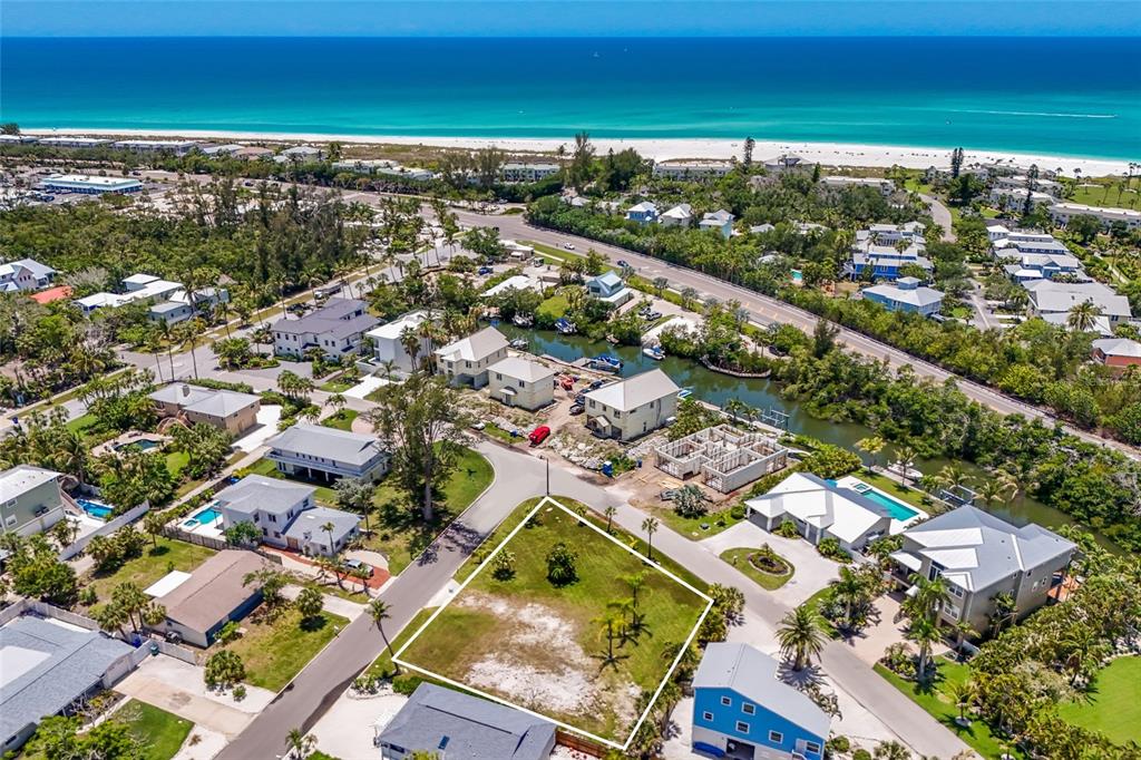 An aerial view shows a vacant, rectangular residential lot surrounded by houses and a canal — 591 RUSSELL STREET, LONGBOAT KEY, FL