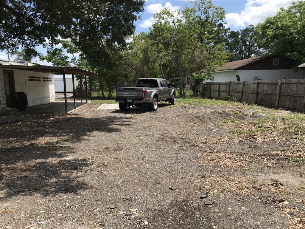 A gray pickup truck is parked on a dirt lot next to a covered patio — 204 SNIVELY AVENUE, ELOISE, FL
