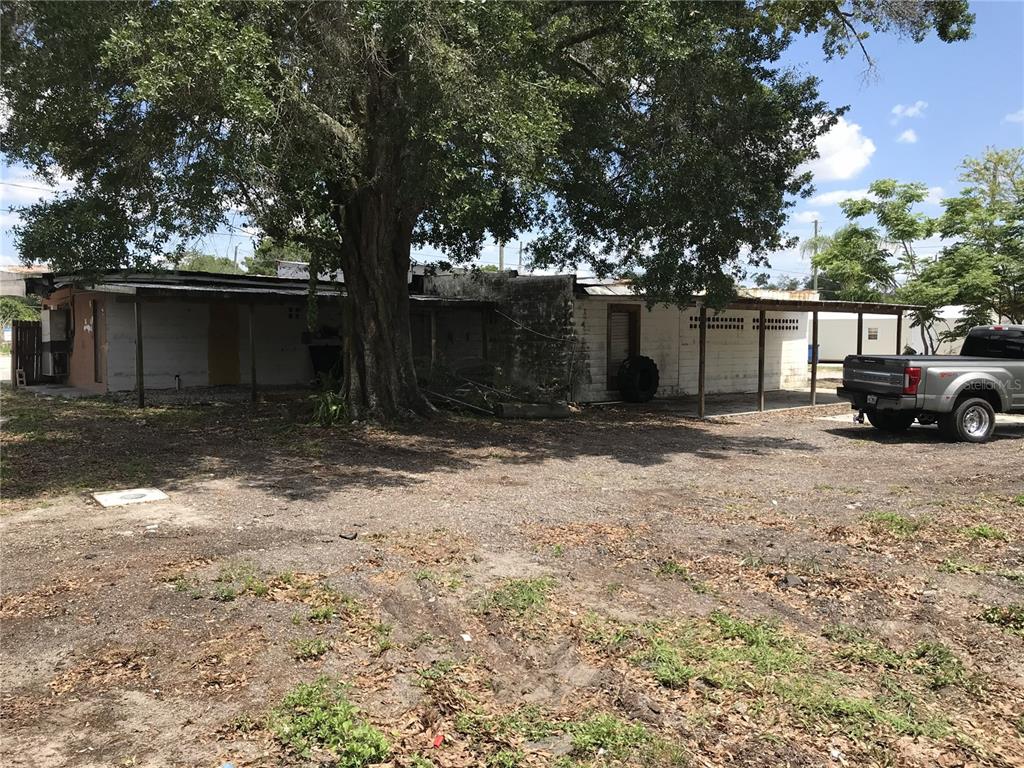 A single-story building with a covered porch and a large tree in the front yard — 204 SNIVELY AVENUE, ELOISE, FL