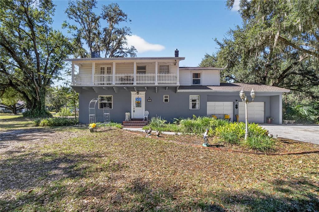 A two-story house with a gray exterior, a white upper balcony, and an attached garage — 2203 HIDDEN POND ROAD, PLANT CITY, FL