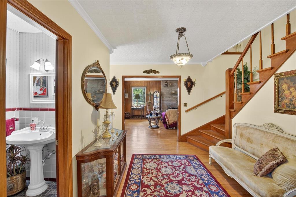A foyer with a staircase, a pedestal sink in a bathroom, and a living room beyond — 2203 HIDDEN POND ROAD, PLANT CITY, FL