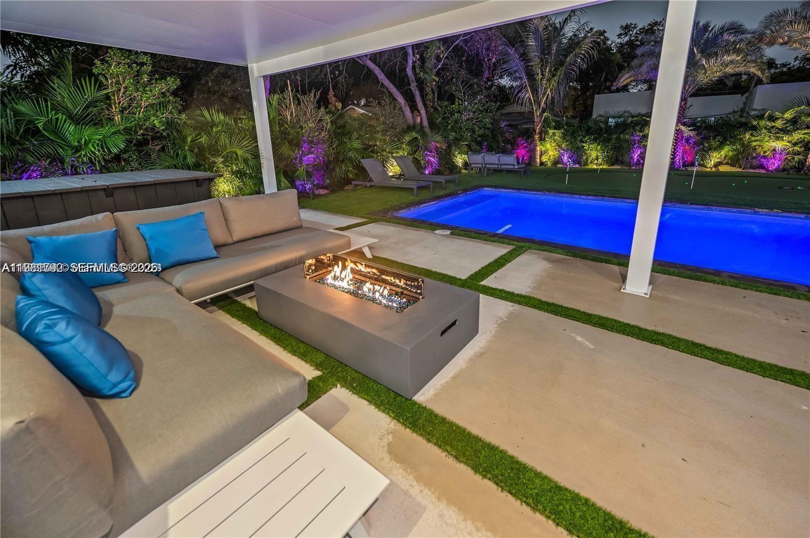A covered patio features a sectional sofa, a fire pit, and a view of a pool — 155 NW 51st St # 0, Miami FL 33127, MIAMI, FL
