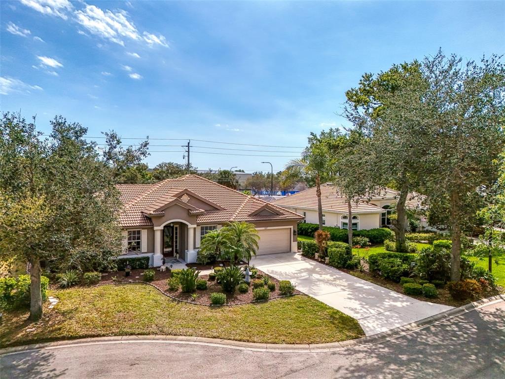 An aerial view of a single-story suburban house with a tile roof and concrete driveway — 107 WAYFOREST DRIVE, VENICE, FL