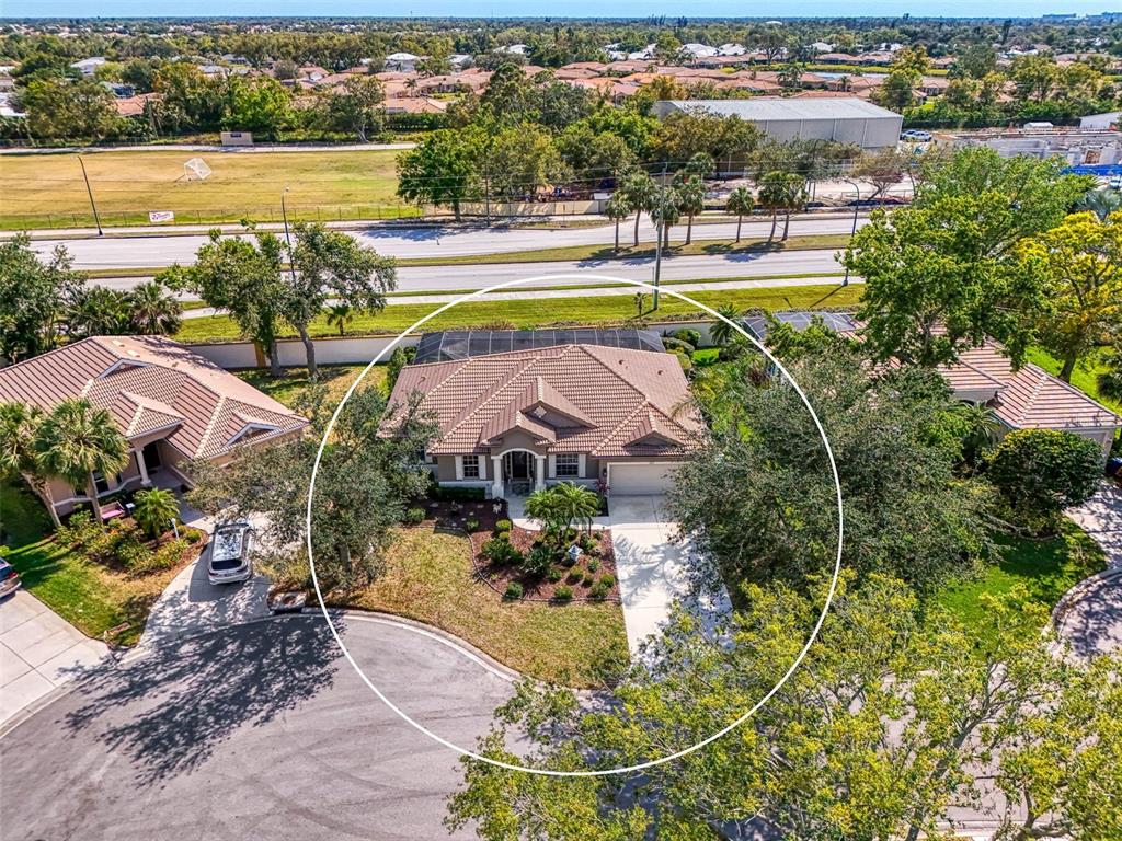 An aerial view shows a single-story house with a tiled roof and a screened pool enclosure — 107 WAYFOREST DRIVE, VENICE, FL