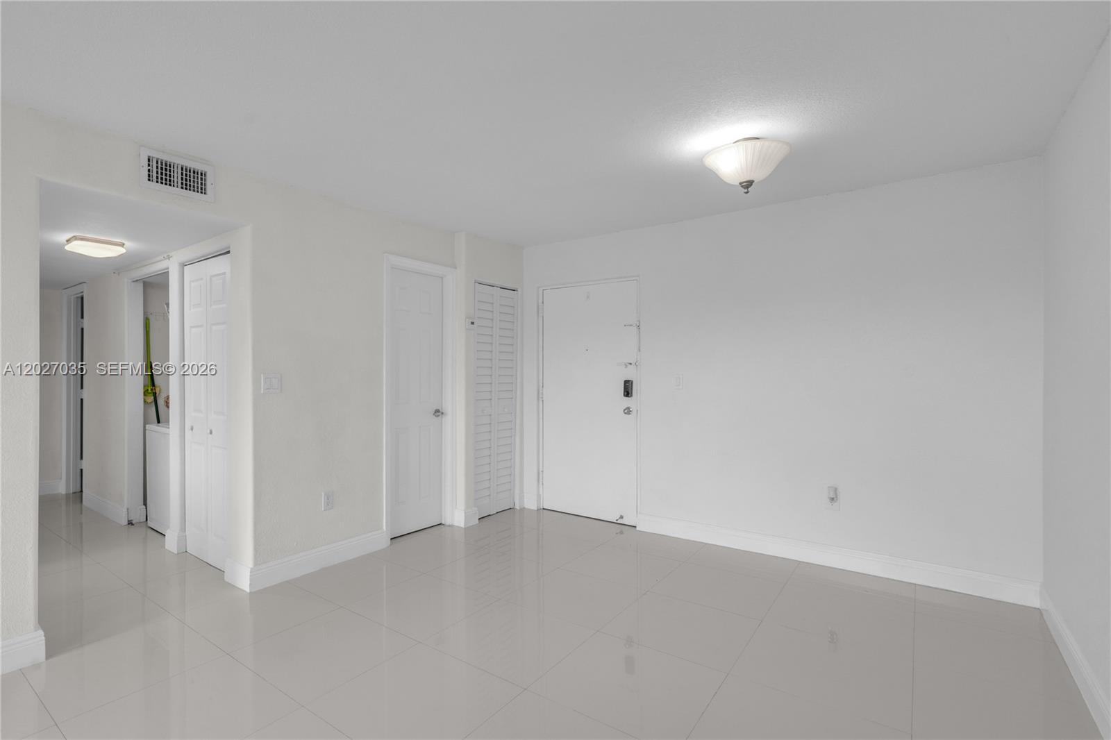 An interior view shows a white-walled room with tiled floors, several doors, and a ceiling light — 9440 W Flagler St # 208, Miami FL 33174, MIAMI, FL