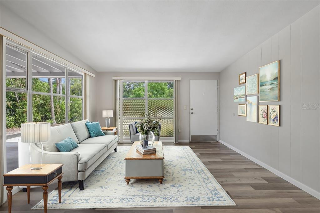 A living room features a sofa, coffee table, area rug, and a gallery wall — 2117 BARCELONA DRIVE, CLEARWATER, FL
