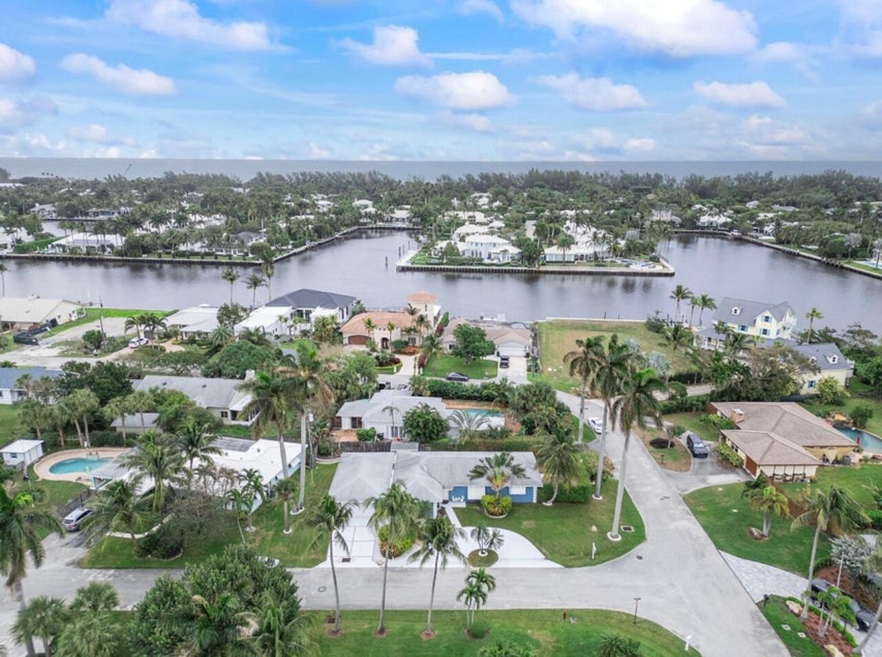 An aerial view of a residential neighborhood featuring waterfront homes, palm trees, and paved streets — 3101 Pierson Drive, Delray Beach FL 33483, DELRAY BEACH, FL