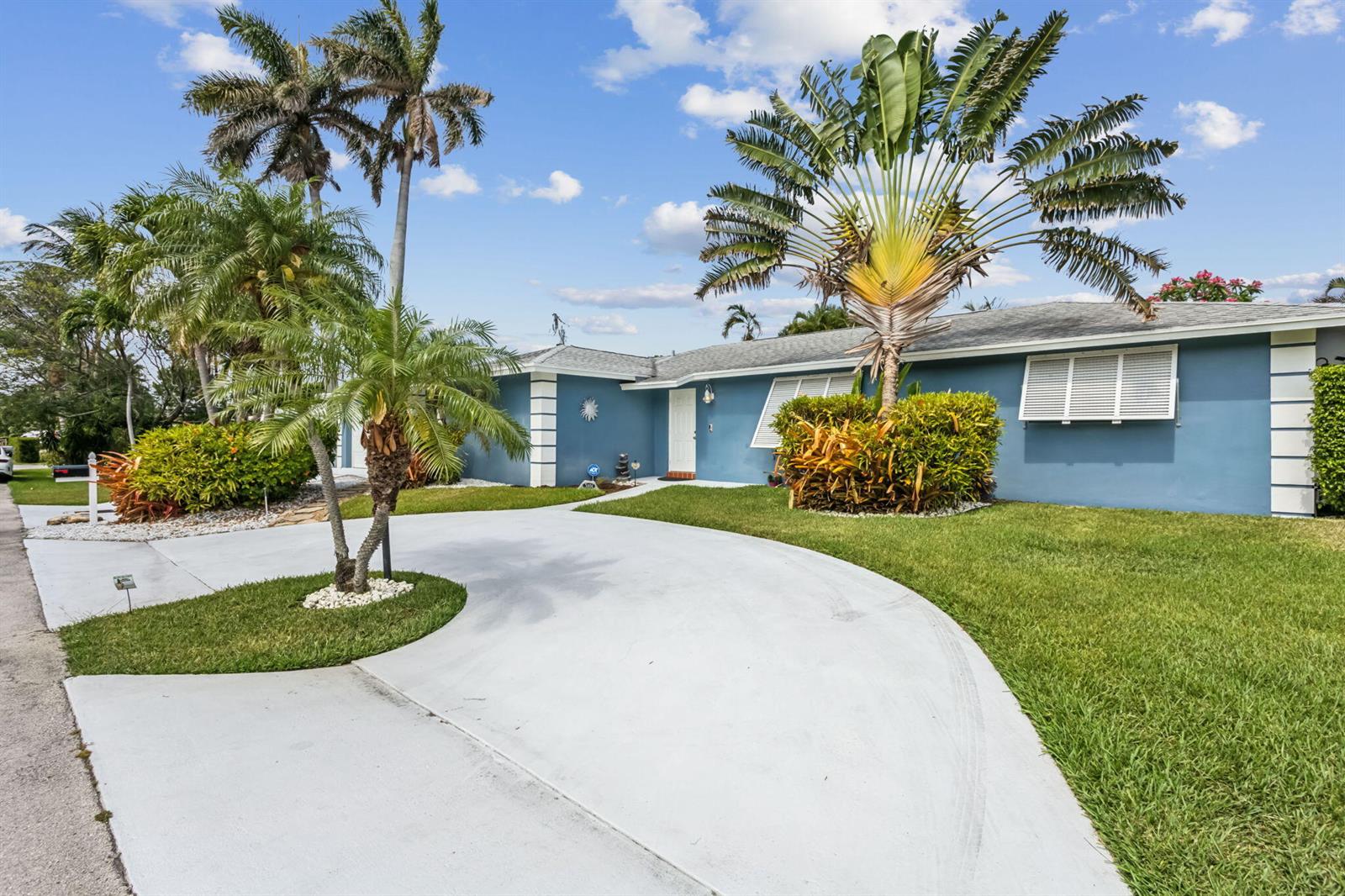 A blue single-story house features a curved concrete driveway and several palm trees — 3101 Pierson Drive, Delray Beach FL 33483, DELRAY BEACH, FL