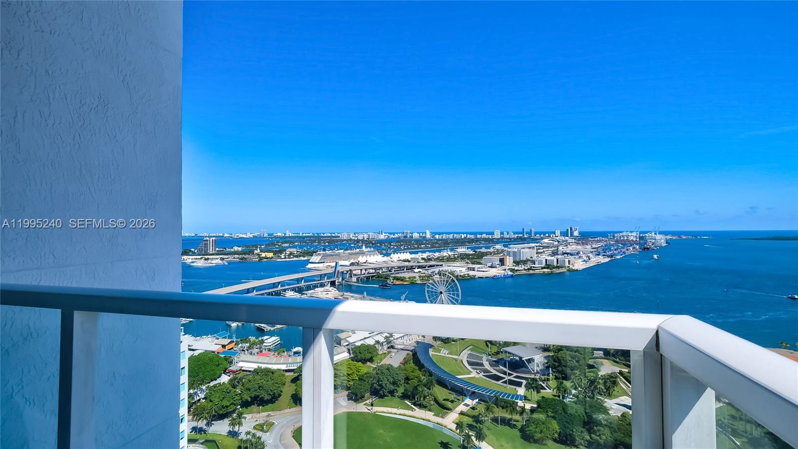 A high-angle view from a balcony overlooking a bay, cruise ships, and a city park — 253 NE 2nd St # 3509, Miami FL 33132, MIAMI, FL