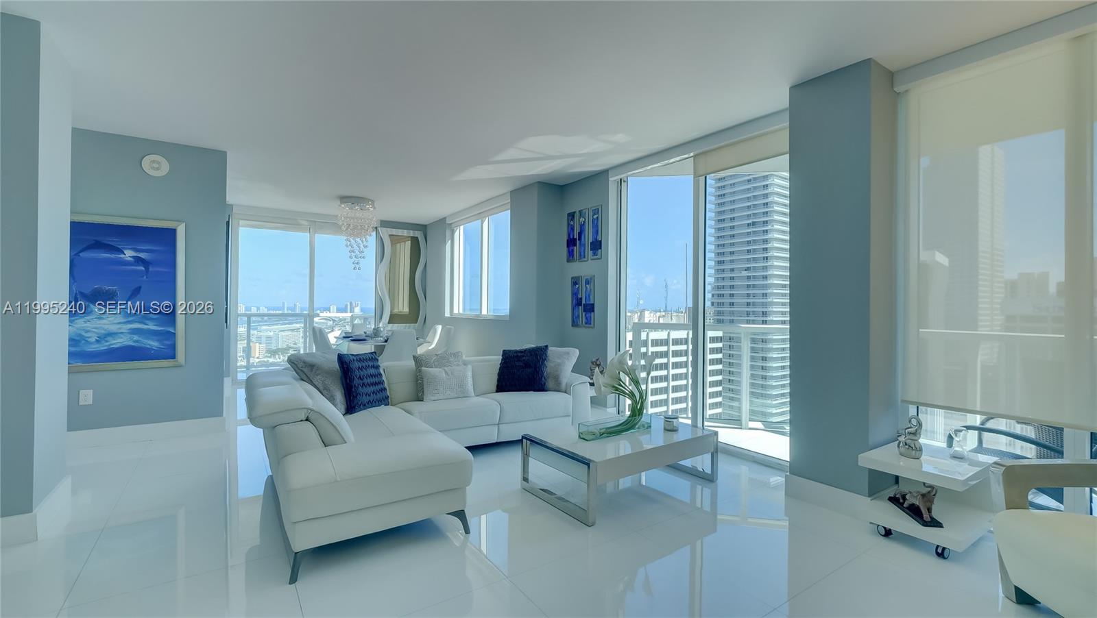 A bright living room features white tile floors, a white sectional sofa, and floor-to-ceiling windows — 253 NE 2nd St # 3509, Miami FL 33132, MIAMI, FL