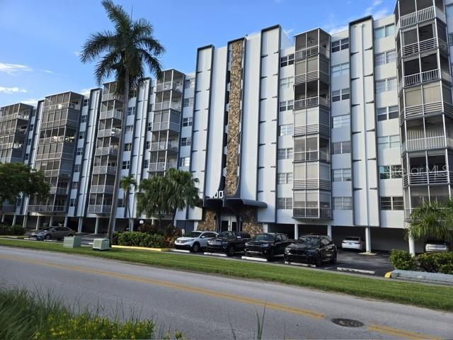 A multi-story apartment building with screened balconies and a stone-accented entrance facade — 300 DIPLOMAT PARKWAY UNIT 203, HALLANDALE BEACH, FL